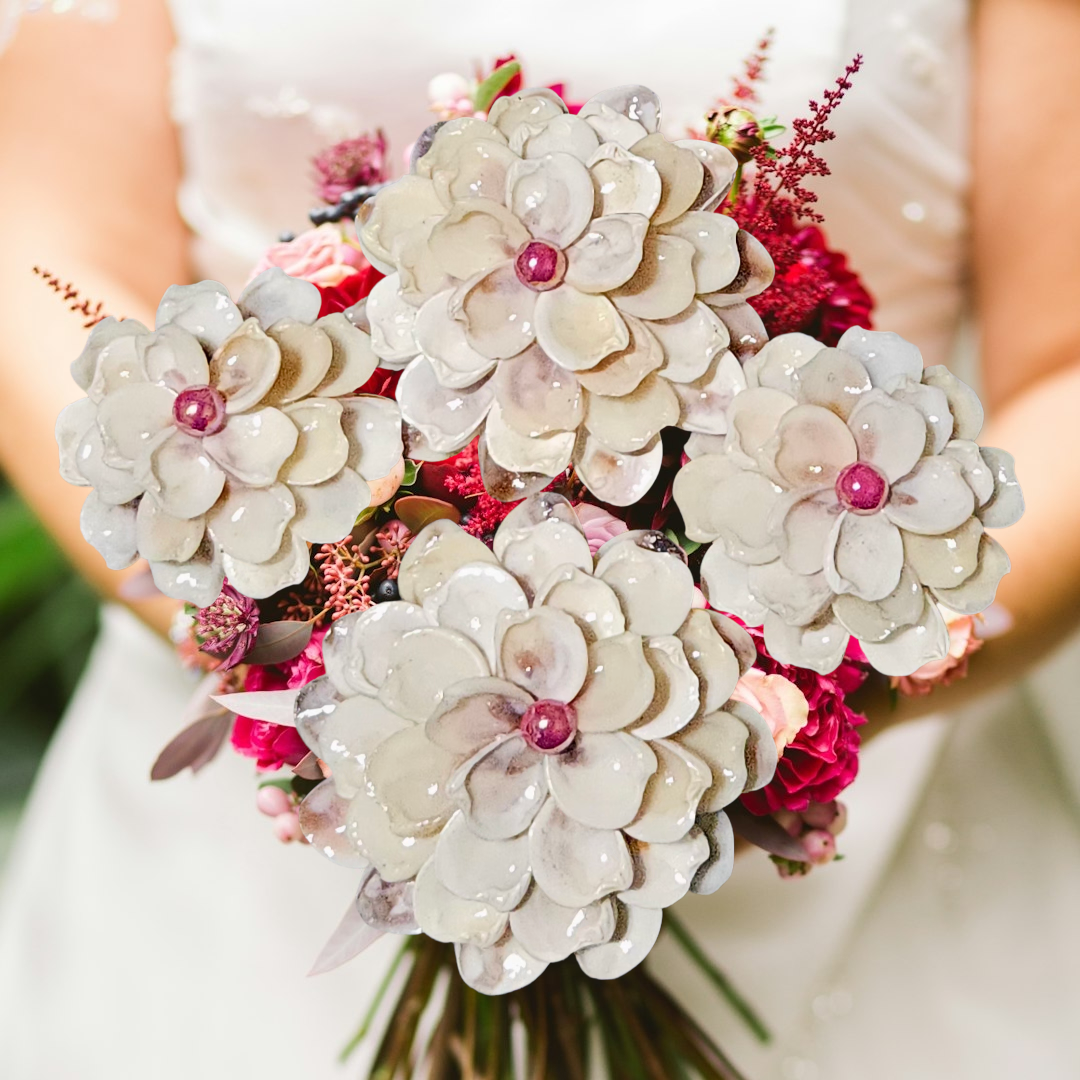 Bold bouquet featuring four ivory shell flowers over bright pink florals.