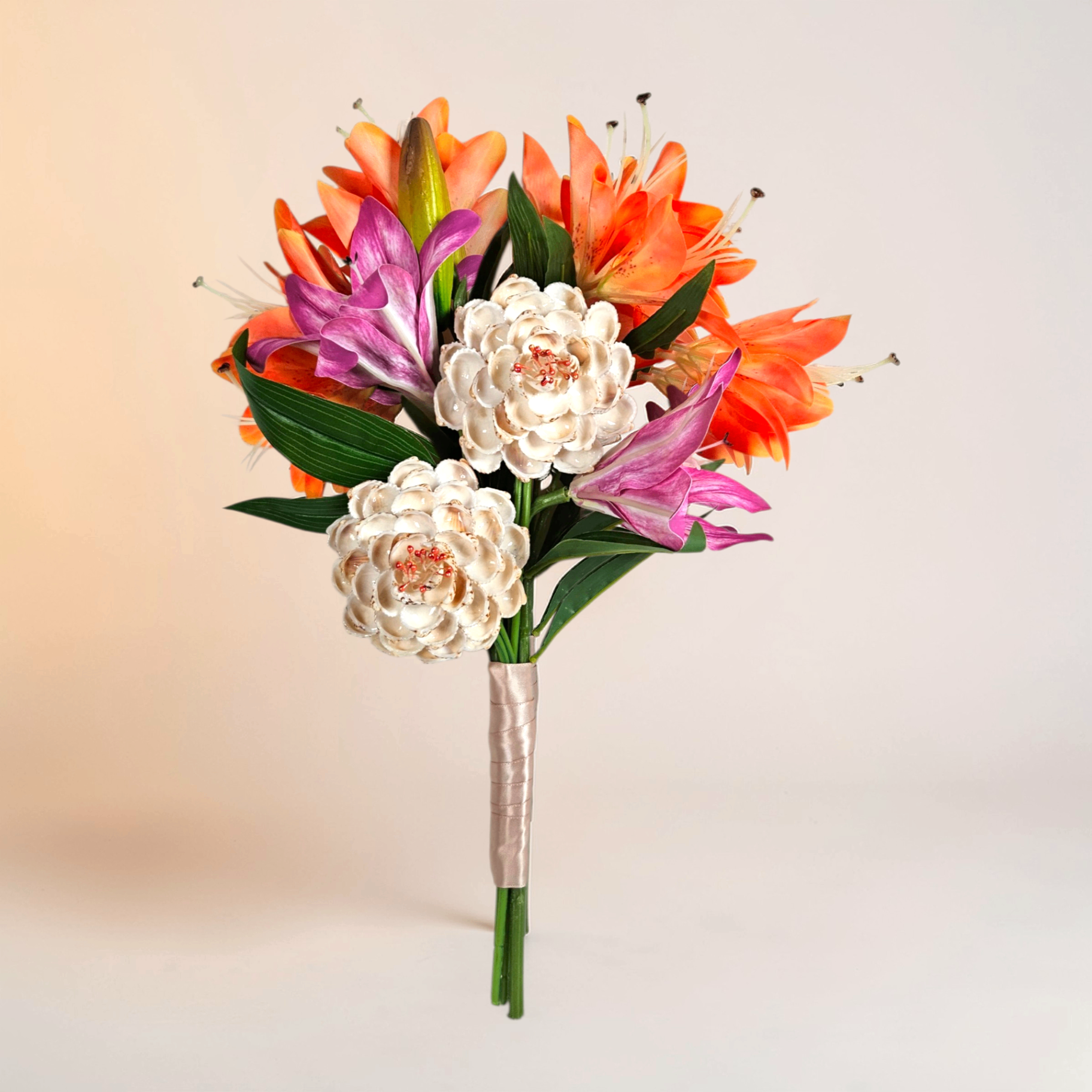 Tropical bouquet with orange lilies, pink lilies, and shell flowers.