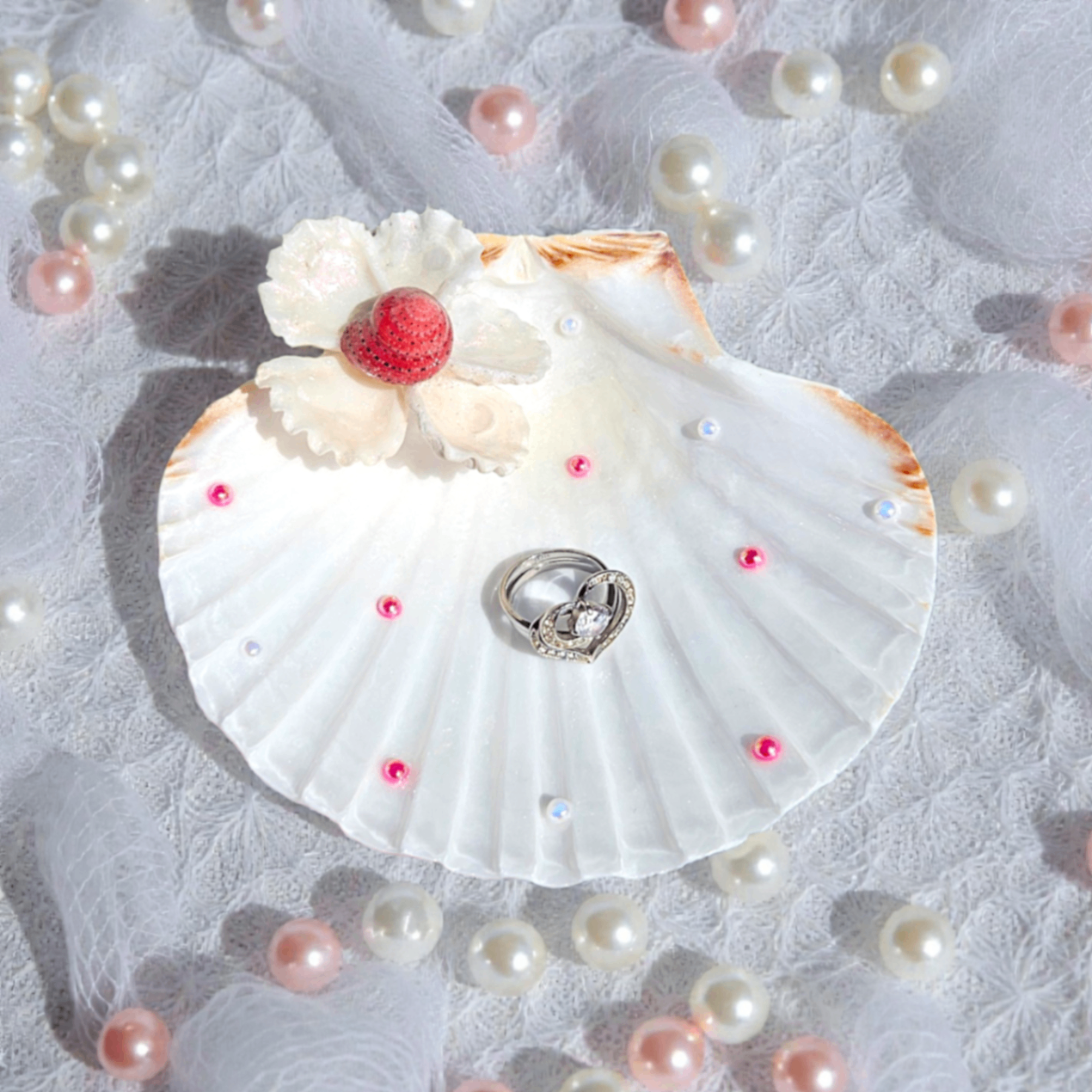 Shell ring dish decorated with blush pearls and a floral accent.
